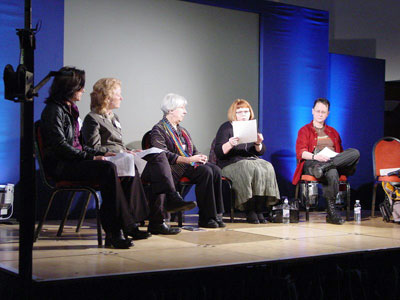 Picture of four people, seated and wired so all can hear what they say, on a stage at YLAF (the York Lesbian Arts Festival).